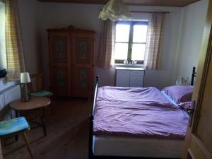 Schlafzimmer mit einem Bett, einem Tisch und einem Fenster in der Unterkunft Leitingerhof in Thalgau