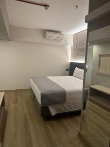 1 dormitorio con 1 cama y suelo de madera en SAN MARINO SUITES HOTEL By NOBILE en Goiânia