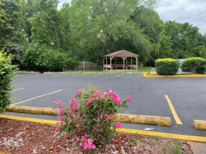 a parking lot with a gazebo and pink flowers at Quality Inn Conference Center Logansport in Logansport