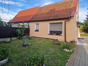 una casa con techo naranja y patio en Domek Pattie en Giżycko