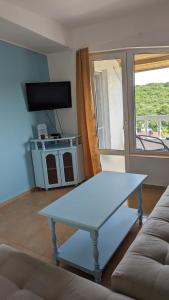 een witte salontafel in een woonkamer met een raam bij Guest House Chalakov in Sinemorets