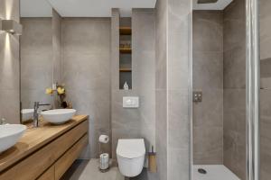 a bathroom with a toilet and two sinks and a shower at Luxury sea view apartment Makarska with pool in Makarska +13 photos