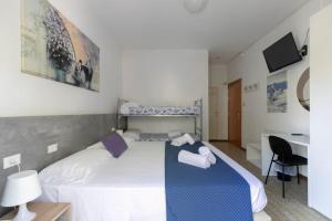 una camera da letto con un letto e asciugamani di Hotel Danieli a Lido di Jesolo