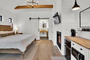 een slaapkamer met een bed en een open haard bij The Scout Boutique Cottages in Sisters