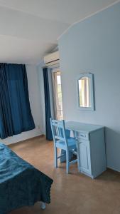 a bedroom with a desk and a chair and a window at Guest House Chalakov in Sinemorets