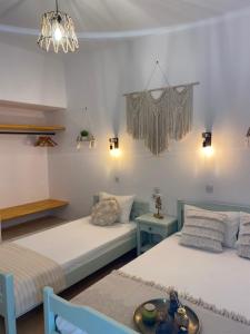 ein Schlafzimmer mit 2 Betten und einem Tisch darin in der Unterkunft Ξενοδοχειο Julietta in Patitiri