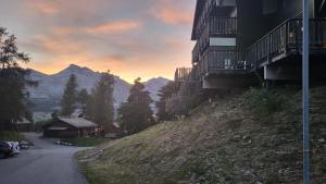 a building on the side of a hill with a mountain at Appartement 4 à 6 personnes - Chalets d'Aurouze - La Joue du Loup in Le Dévoluy +2 photos
