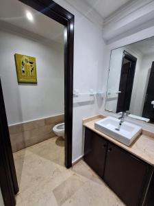 La salle de bains est pourvue d'un lavabo, d'un miroir et de toilettes. dans l'établissement Reservyou, à Casablanca