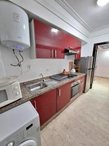 - une cuisine avec des placards rouges et un évier dans l'établissement Reservyou, à Casablanca