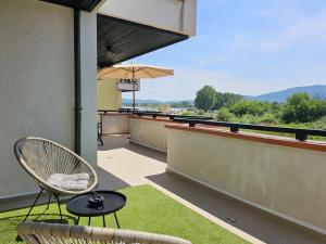 a balcony with a chair and an umbrella at Sea Vacation Homes in Chernomorets