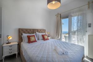 een slaapkamer met een bed en uitzicht op de oceaan bij 3 Paros *All Season* Villas in Parikia