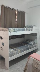 a white bunk bed with two bunk beds in a room at Pousada da Benção in Cachoeira Paulista