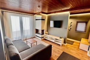 a living room with a couch and a tv at Hidir Yayla Dağ Evi in Akcaabat +6 photos