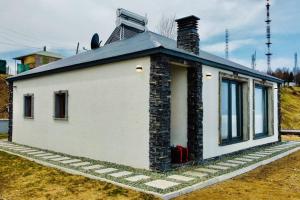 a small white building with a chimney on top at Hidir Yayla Dağ Evi in Akcaabat