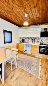a kitchen with a wooden ceiling and a table with chairs at Hidir Yayla Dağ Evi in Akcaabat