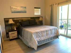 a bedroom with a bed with a nightstand and a window at Bahama Bay- Two bedrooms condo fully equipped in Kissimmee