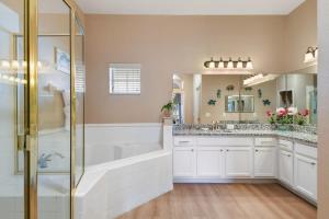 a bathroom with a shower and a tub and a sink at Bahama Bay Huge Penthouse condo in Kissimmee +30 photos