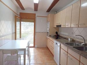 a kitchen with a sink and a table with chairs at Casa Carmeta Beceite in Beceite