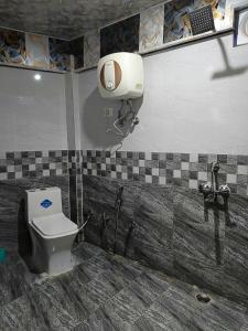 a bathroom with a toilet and a phone on the wall at Hotel Fateh Heights in Pāndukeshwar