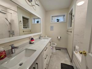 a bathroom with a sink and a shower and a toilet at Newly-renovated 3BR house, 12 minutes to Airport in Toronto