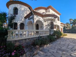 a white house with a white fence and flowers at Villa Isalina in Miami Platja
