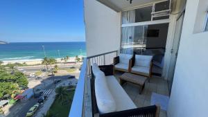 balcón con sofá y vistas a la playa en Vista para o mar Barra da tijuca, en Río de Janeiro