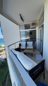 balcón con 2 bancos y sala de estar. en Vista para o mar Barra da tijuca, en Río de Janeiro