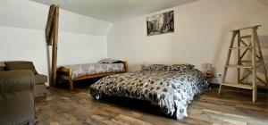 a bedroom with a bed and a ladder in it at Maison Saint Côme du Mont in Saint-Côme-du-Mont