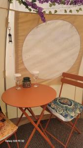 een tafel en twee wijnglazen op een stoel bij glamping in Dromineer in Dromineer