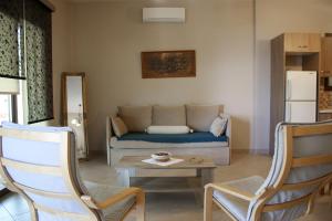 a living room with a couch and a table and chairs at Studios Liotrivi Ouranoupolis in Ouranoupoli