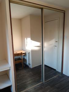 a mirror in a room with a door and a desk at Glasgow Millroad Private Room in Glasgow