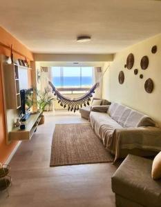 a living room with a couch and a television at Ritasol Palace apartamento de relax frente al mar in Caraballeda