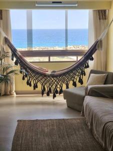 a hammock in a living room with a view of the ocean at Ritasol Palace apartamento de relax frente al mar in Caraballeda