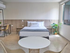 a hotel room with a bed and a table and chairs at Elemont Hotel in Medellín