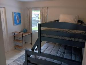 ein Schlafzimmer mit einem Etagenbett und einem Fenster in der Unterkunft Home Away From Home in Vero Beach