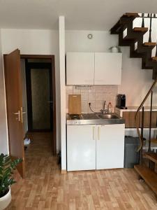 a kitchen with white cabinets and a staircase at Maisonette Wohnung im Herzen Göttingens in Göttingen