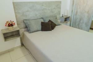 uma cama com duas almofadas num quarto em VISTA PRAIA MAR - AVIAÇÃO - 300 metros da praia - WI FI - VARANDA GOURMET com CHURRASQUEIRA - ESTACIONAMENTO gratuito na Praia Grande
