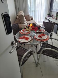 einen Tisch mit Teller Essen darauf im Wohnzimmer in der Unterkunft VISTA PRAIA MAR - AVIAÇÃO - 300 metros da praia - WI FI - VARANDA GOURMET com CHURRASQUEIRA - ESTACIONAMENTO gratuito in Praia Grande
