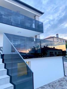 ein Haus mit einer Glasfassade mit einer Treppe in der Unterkunft Seaview Villa Koper in Koper