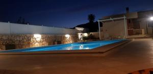 - une piscine en face d'une maison la nuit dans l'établissement VILLA SESIFE Avola, à Avola