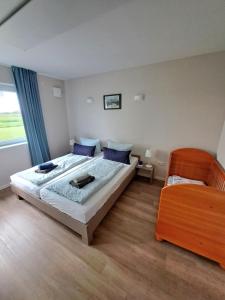 a bedroom with a large bed with blue pillows at Ferienwohnungen Weide-Meer-Watt in Großheide