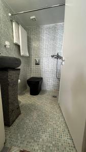 a bathroom with a black toilet and a sink at Astypalea Apartments in Astypalaia Town