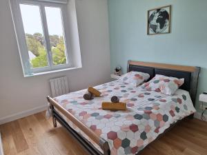 a bedroom with a bed with two teddy bears on it at Appartement au cœur de la Côte de Granit Rose. in Trégastel