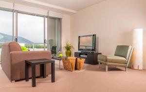 a living room with a couch and a chair and a television at Cairns Private Apartments in Cairns