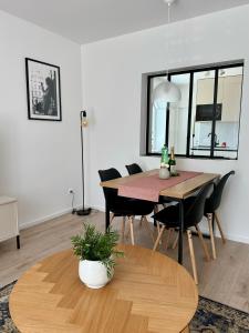 a dining room table with chairs and a table with a plant at Apartment ZANzi in Šamorín