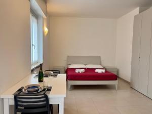 a bedroom with a red bed and a table and chairs at Valpolicella Veneto1 in Negrar