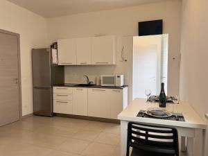 a kitchen with white cabinets and a table with wine glasses at Valpolicella Veneto1 in Negrar
