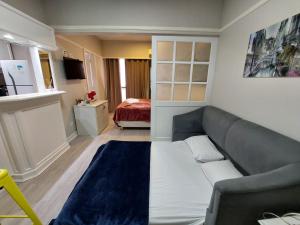 - un salon avec un canapé et un lit dans l'établissement Flat Champ's Elysées, à São Paulo