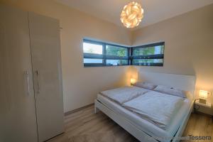 1 dormitorio con cama y lámpara de araña en Apartment Tessera en Wernigerode