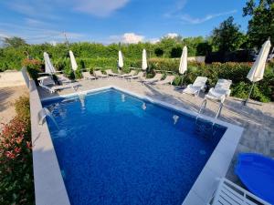 a swimming pool with chairs and umbrellas at Apartments Lea with pool 2 in Malinska